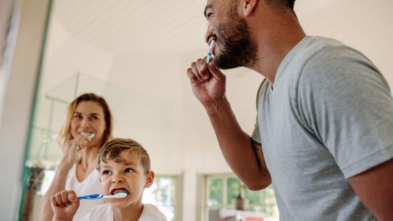 Family brushing teeth together to prevent dental emergencies